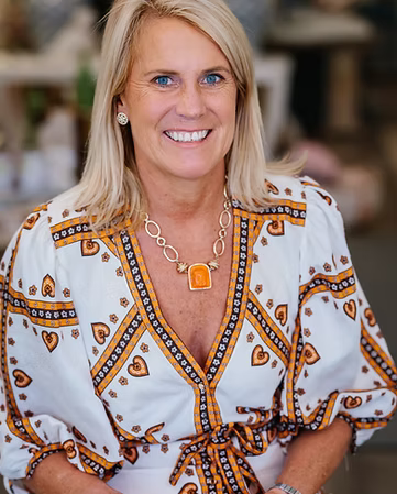 Woman wearing a patterned blouse with a blurred background