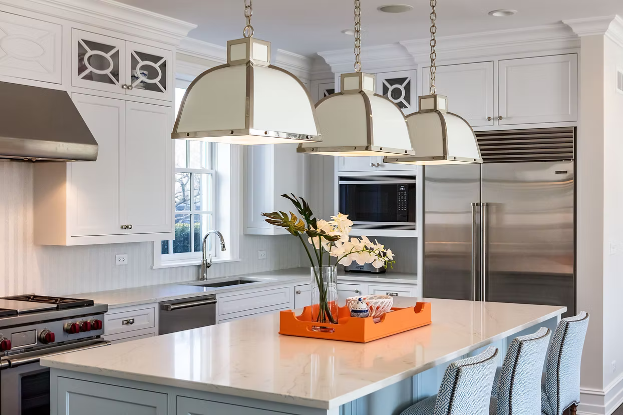 Modern kitchen with white cabinets, stainless steel appliances, and a decorative island.