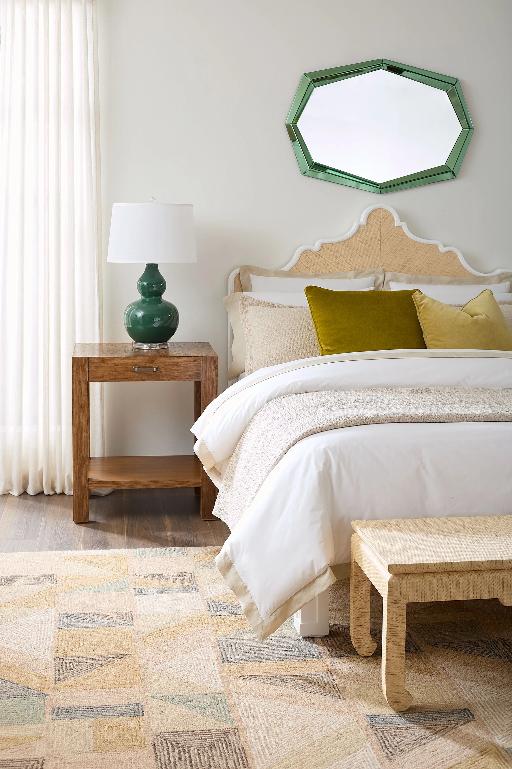 Neatly made bed with decorative pillows in a bedroom setting.